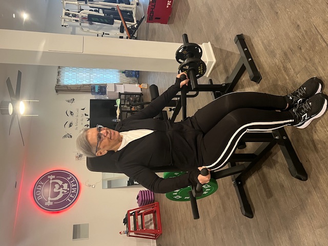 Body Temple VA member training on the seated leg machine at 76